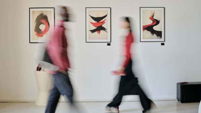 people-walk-past-abstract-art-in-gallery