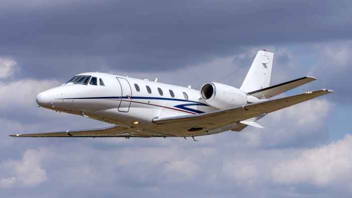 white-private-jet-flying-through-cloudy-blue-sky (1)
