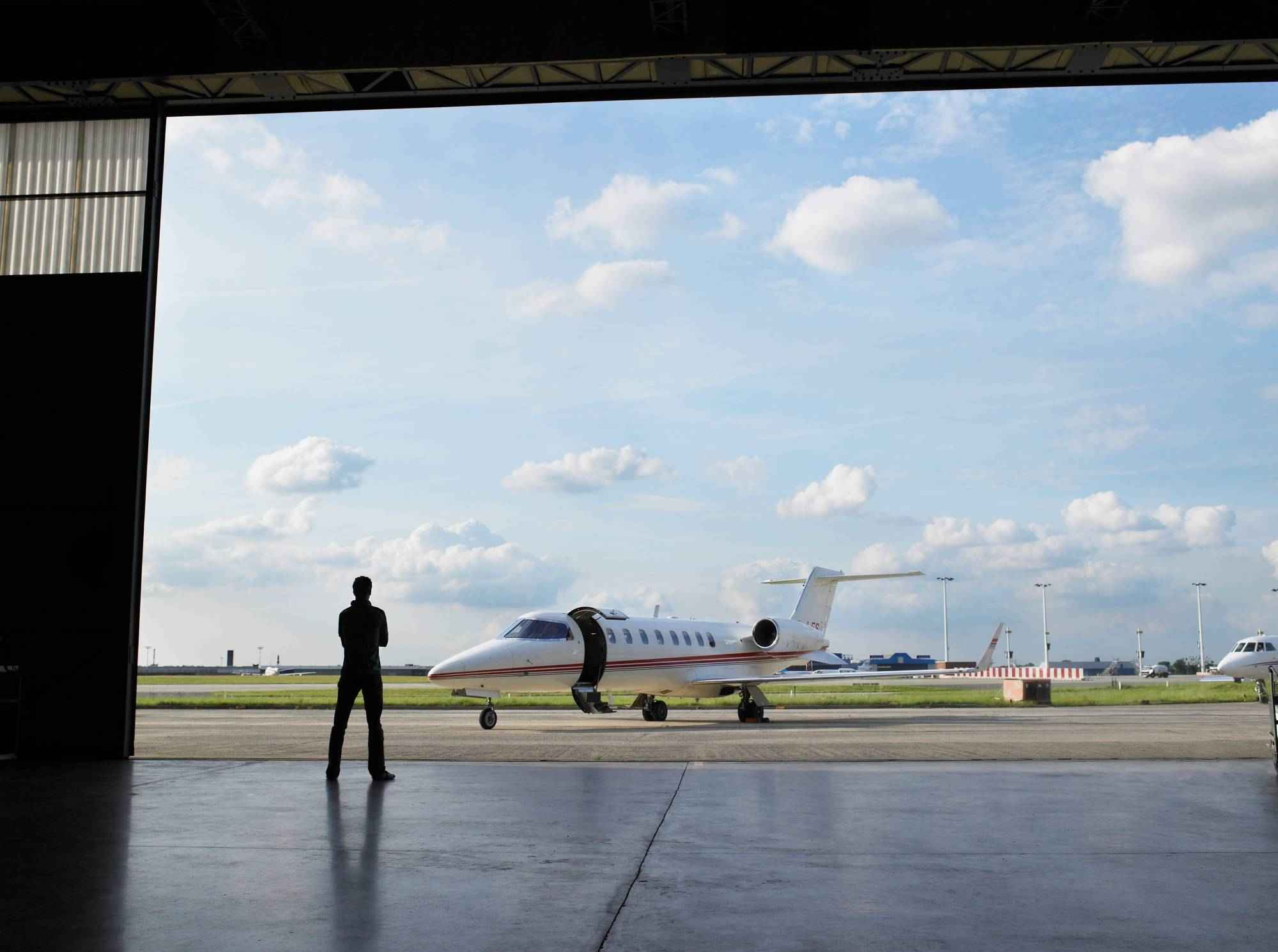 silhouette-of-person-by-airplane-on-tarmac-