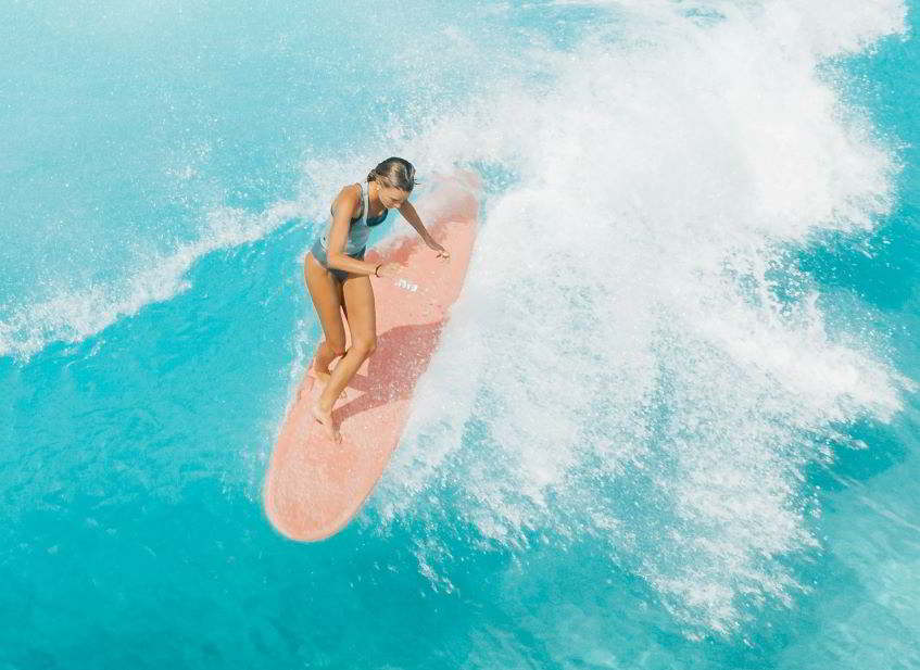ragazza che surfa nelle Isole Cayman