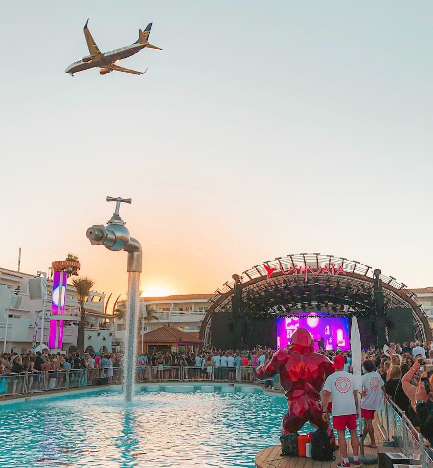 view of party in ibiza and a plane in the sky