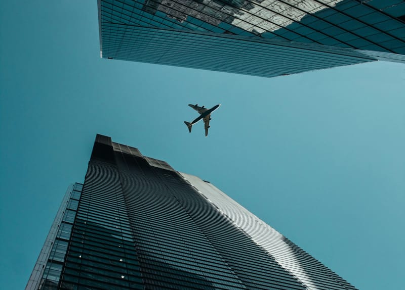 Aereo che vola tra due grattacieli | Fast Private Jet