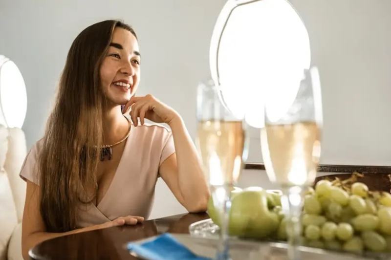 Donna beve champagne su un volo su un jet privato